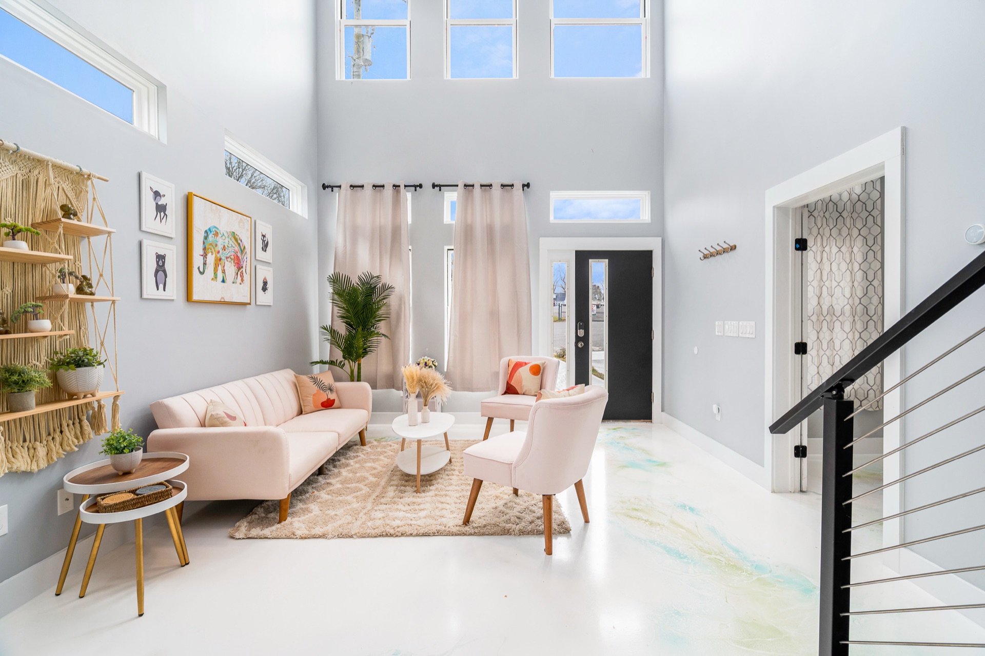 Bright two-story living room with blush sofa and glossy epoxy floor