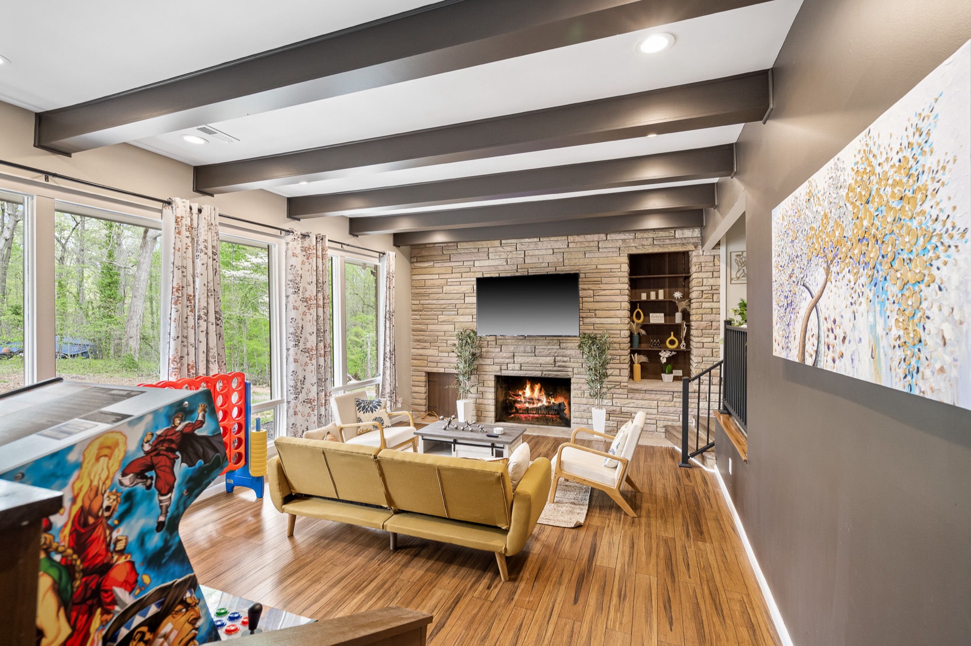 Renovated living room with stacked-stone fireplace and exposed beams in a Raleigh home