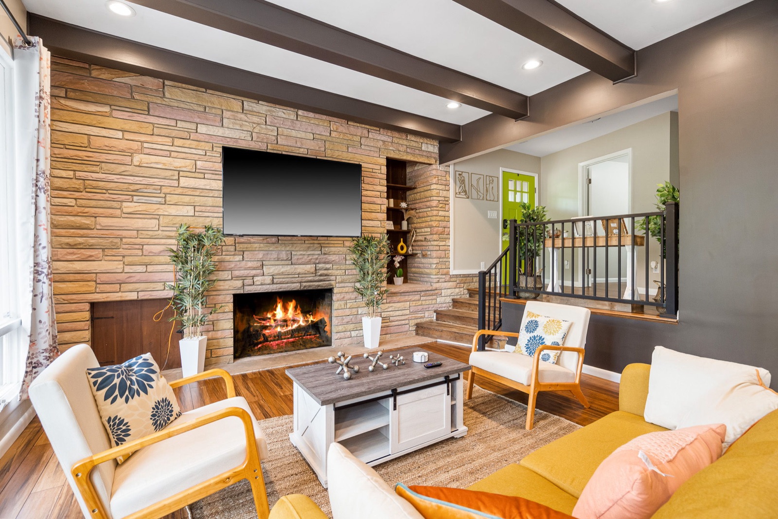 Living room with floor-to-ceiling stone accent wall and fireplace